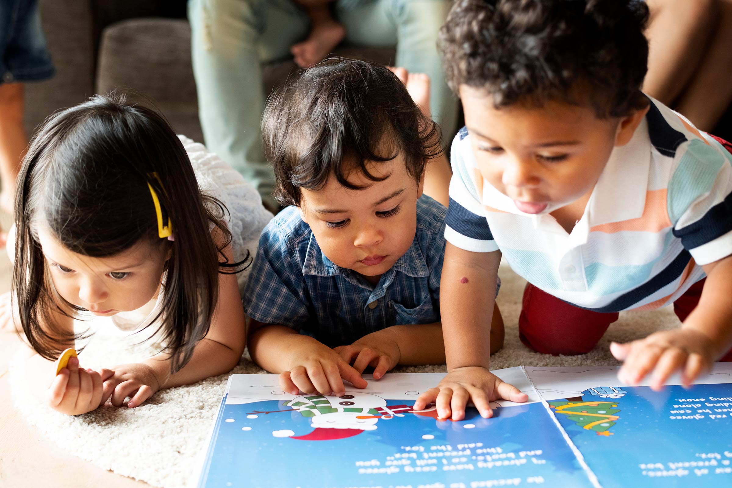 Children reading a book on the floor