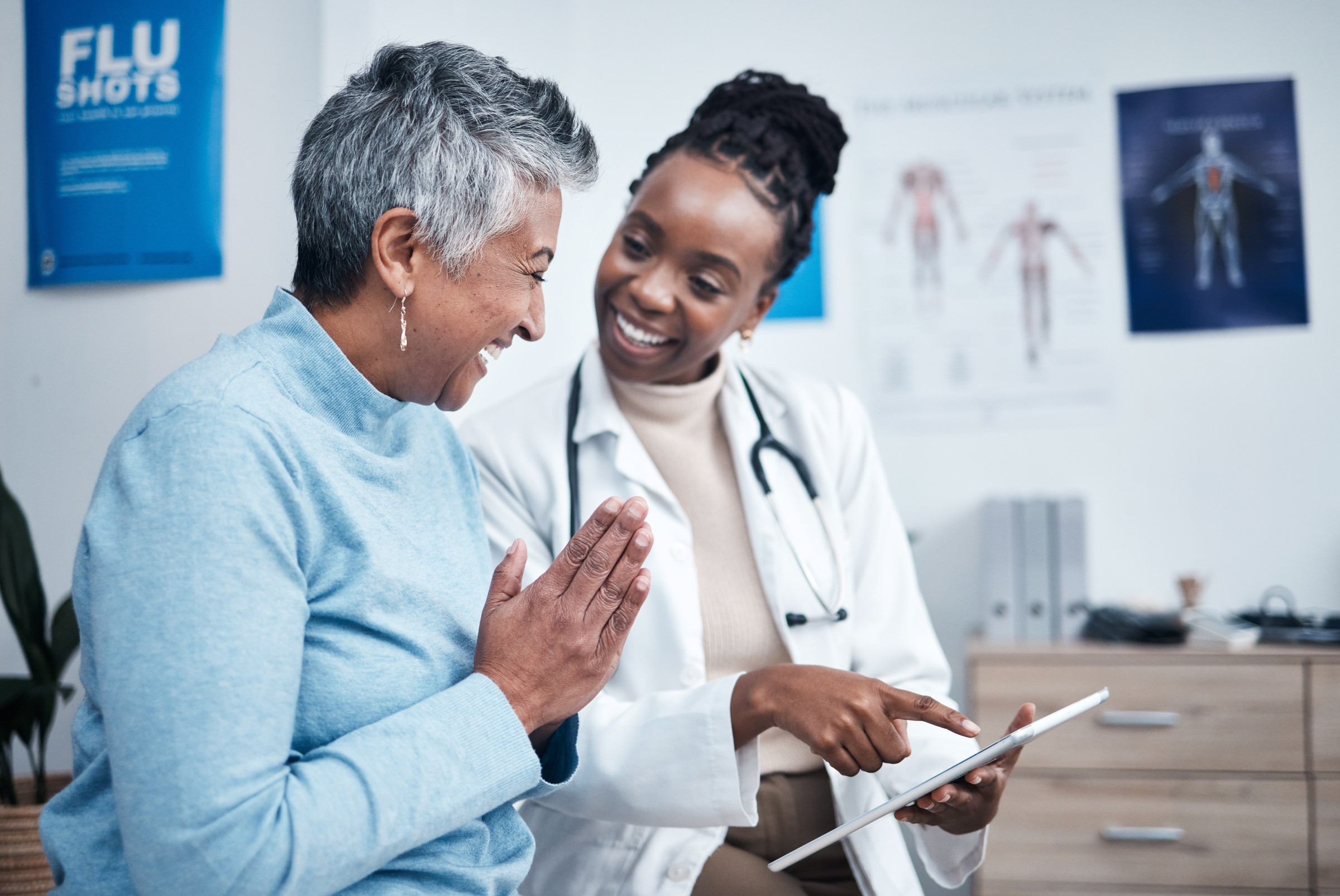 young female doctor consulting with an older smiling female patient