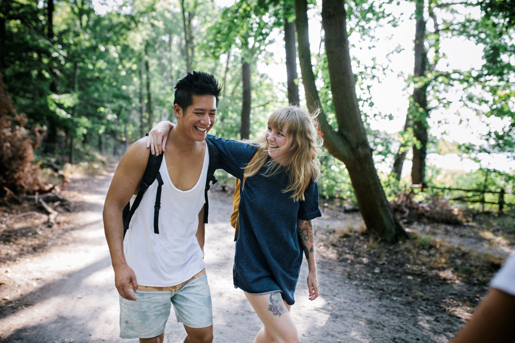 smiling man and woman walking in the woods