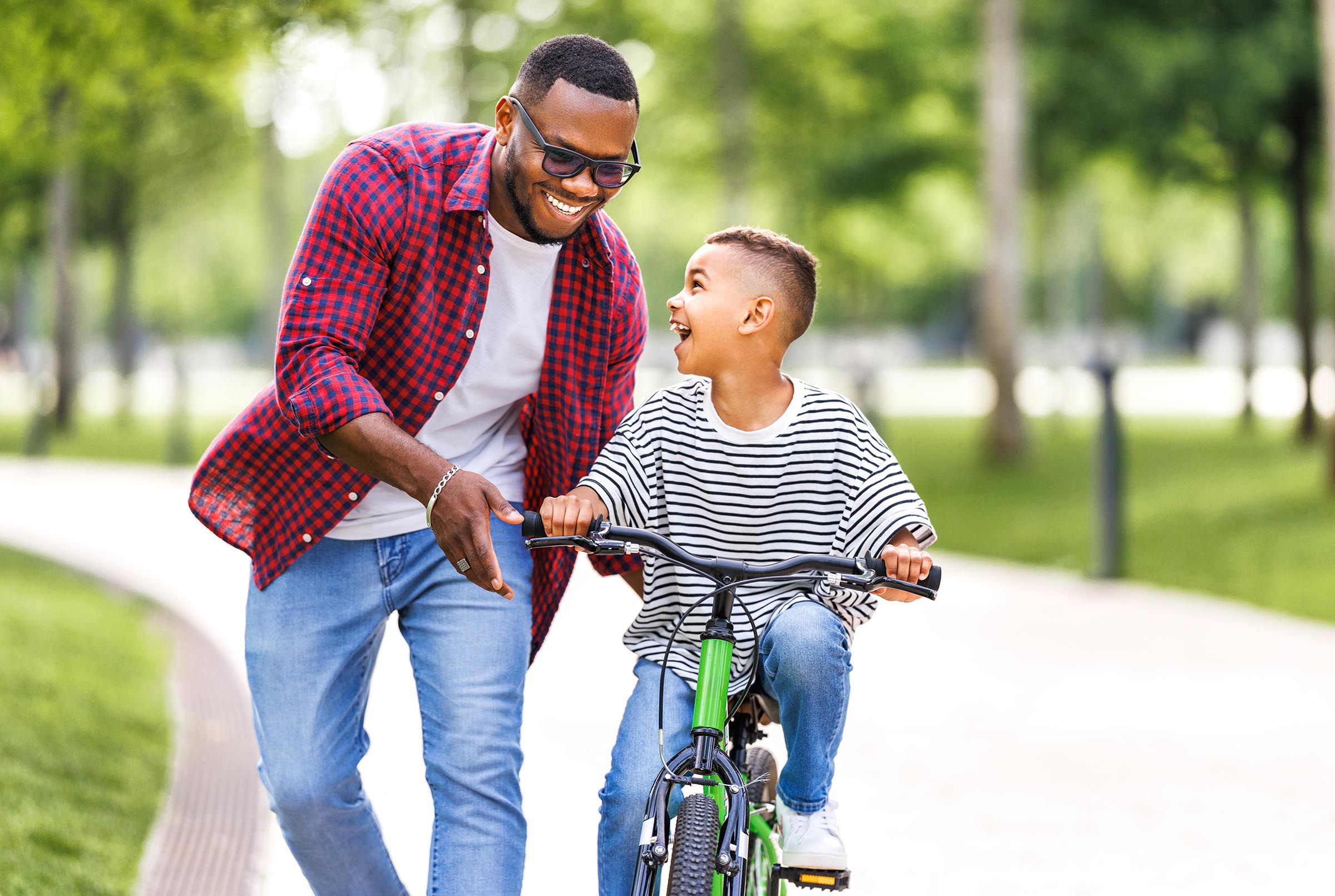 Man helping boy learn how to ride a bike