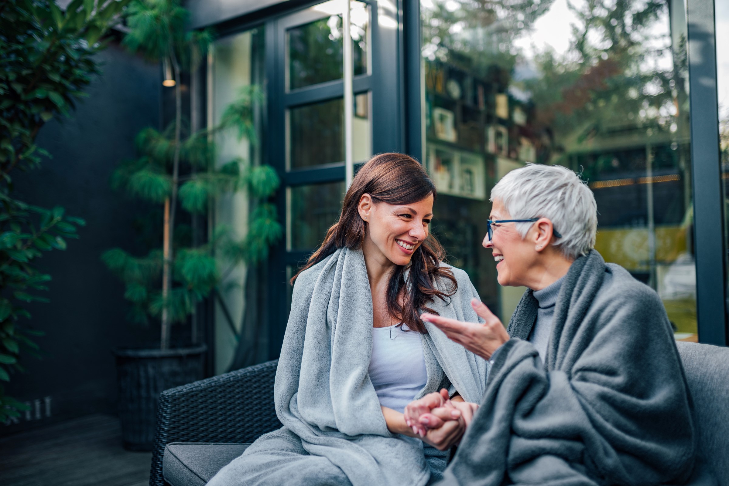 two smiling women sitting together talking