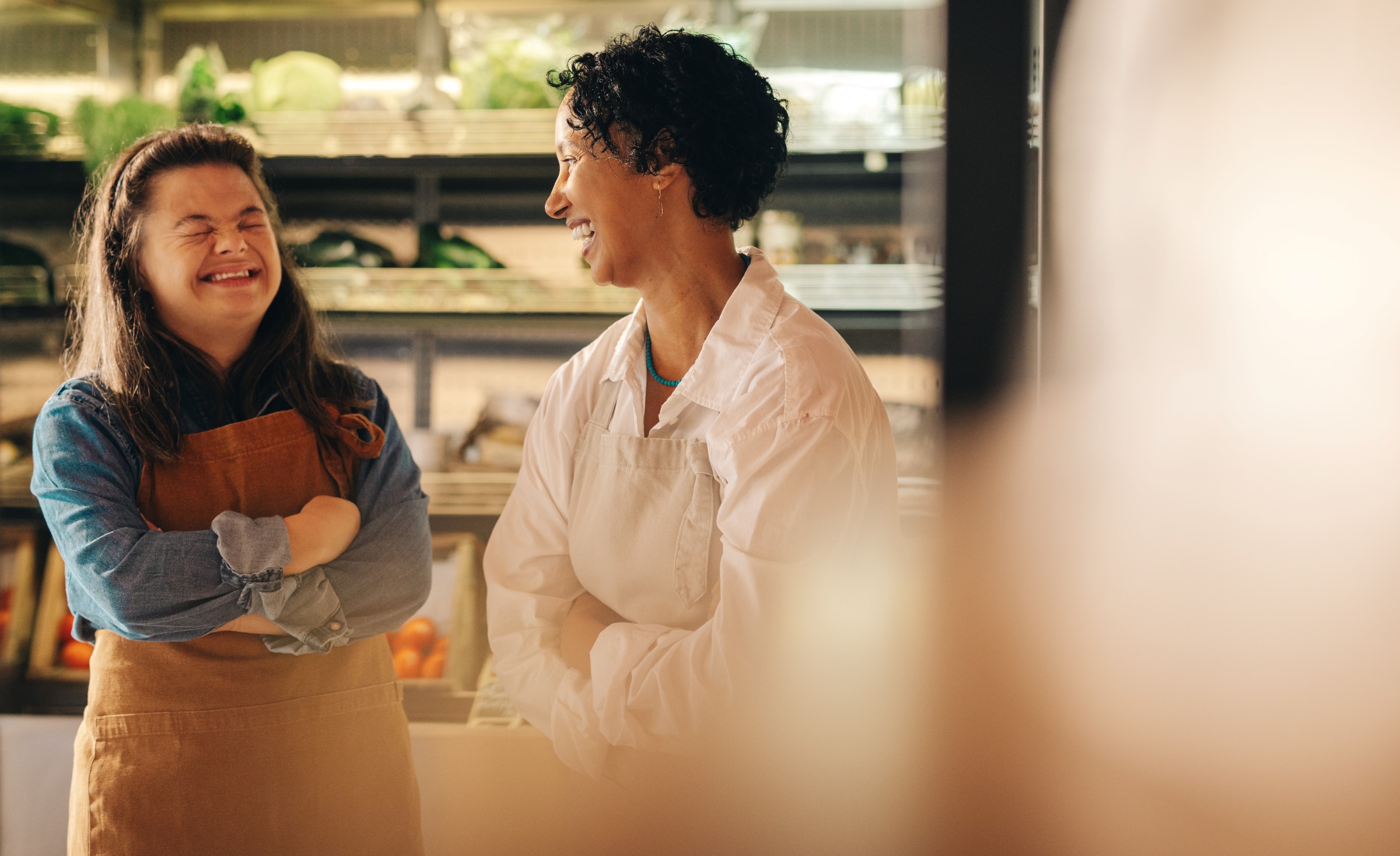 two female grocery store employees chatting and laughing