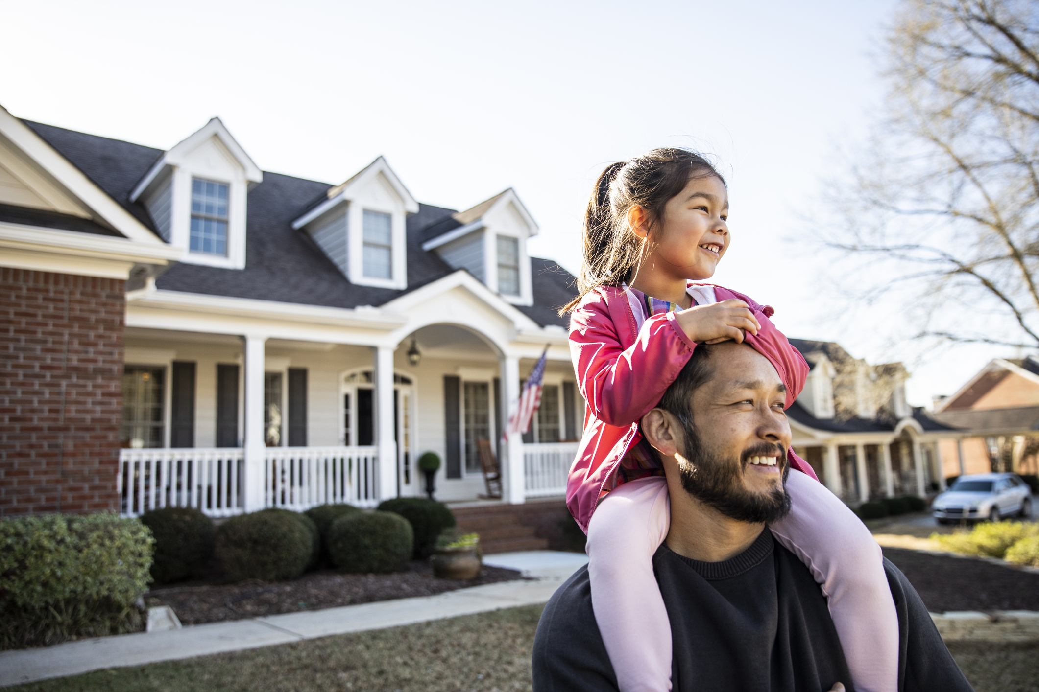 man with his daughter sitting on his shoulders