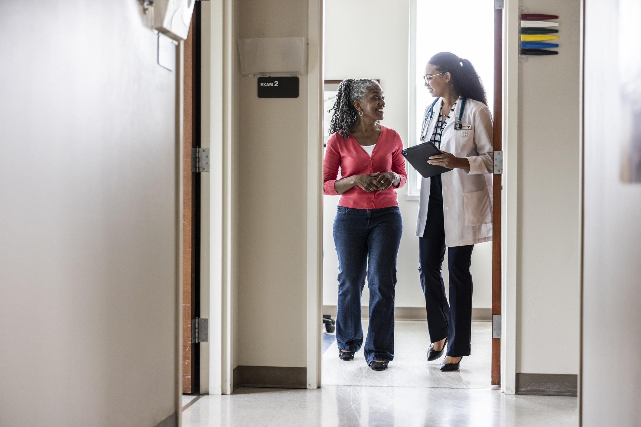 female doctor and patient discussing while leaving exam room